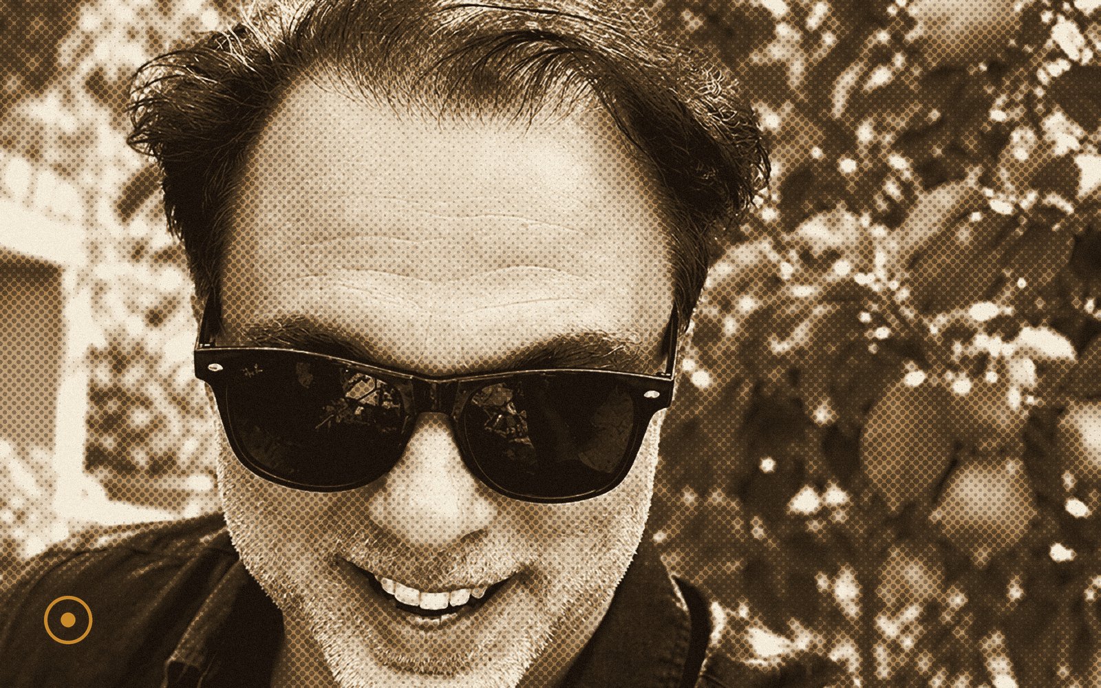 Mario Noioso smiling in sunglasses outdoors, sepia halftone portrait